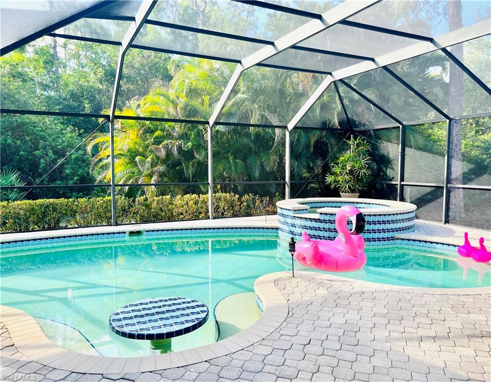 3221 64th Street Southwest Naples, FL 34105 - Photo 1 of 12 View of swimming pool featuring an in ground spa, a paver patio, and a lanai