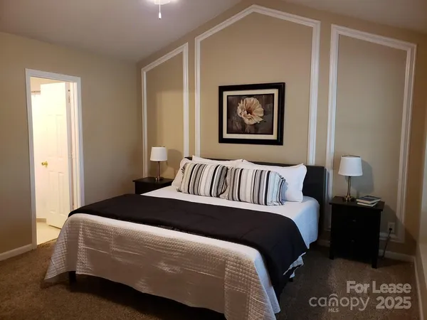 a bedroom with a bed and a painting on the wall