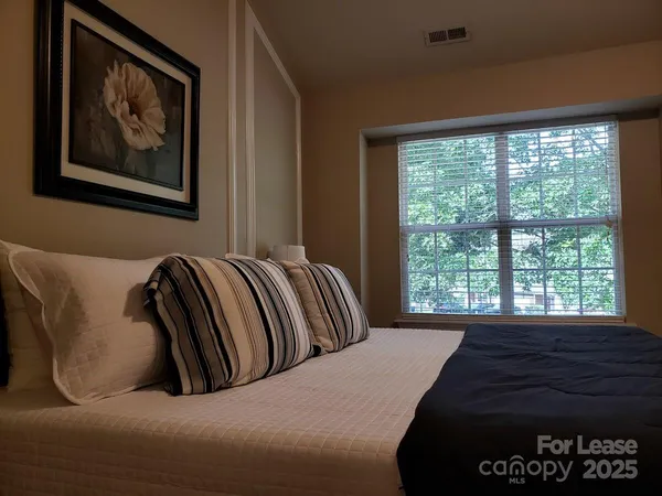 a bed sitting in a bedroom next to a window