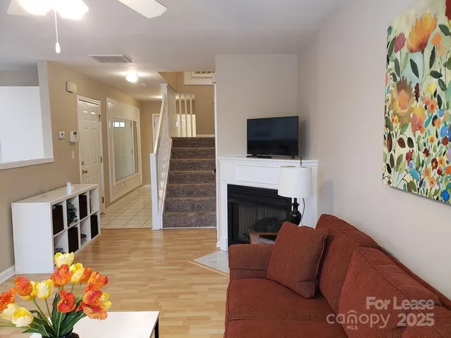 a living room with furniture a flat screen tv and a fireplace
