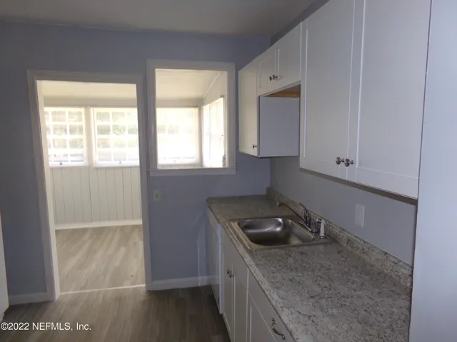 a kitchen with granite countertop a sink and a stove