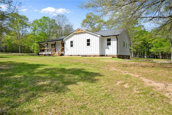 a kitchen with stainless steel appliances granite countertop a refrigerator a stove top oven a sink dishwasher and white cabinets with wooden floor