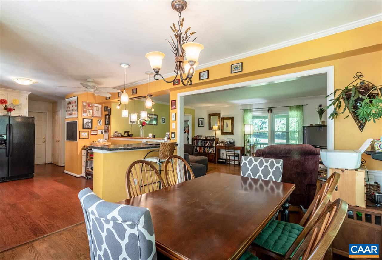 a living room with furniture a chandelier and a dining table