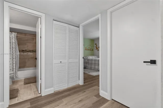 an empty room with wooden floor and a glass door