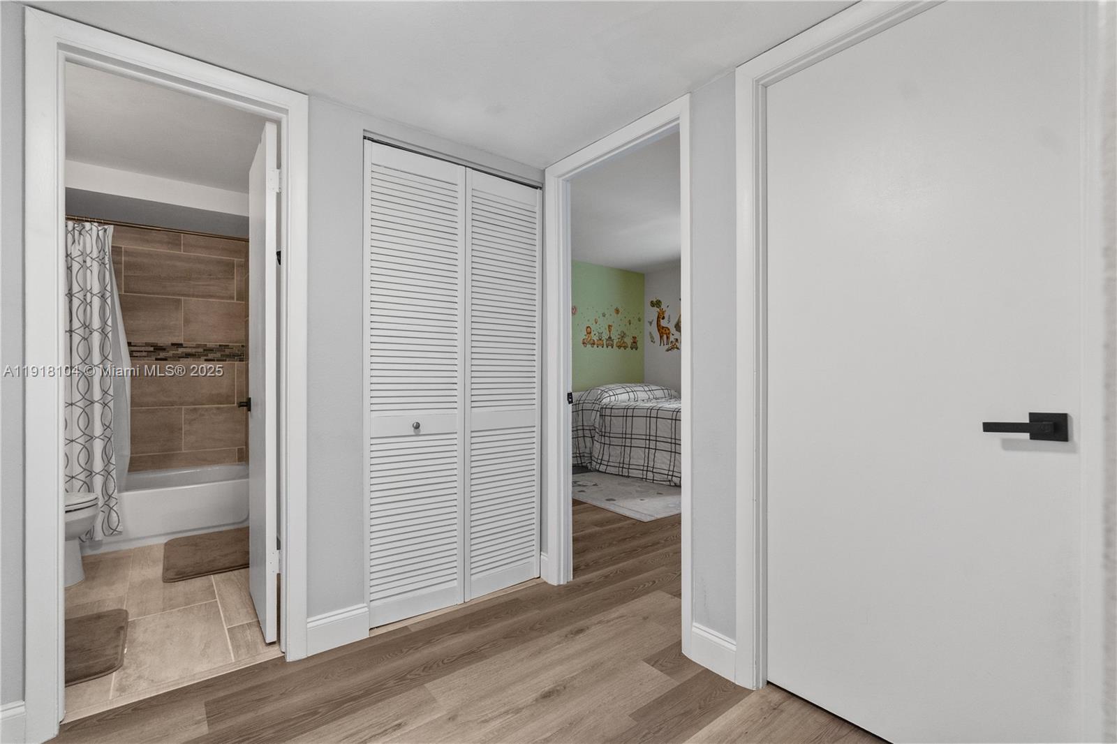 8089 Southwest 18th Court, Unit 27 Davie, FL 33324 - Photo 16 of 36 an empty room with wooden floor and a glass door