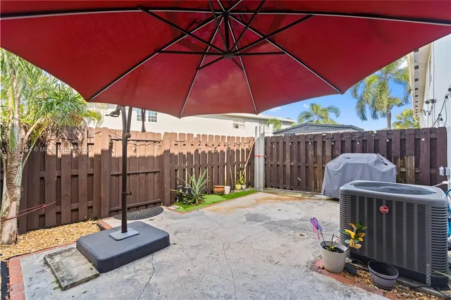 a view of a patio with a table and chairs under an umbrella