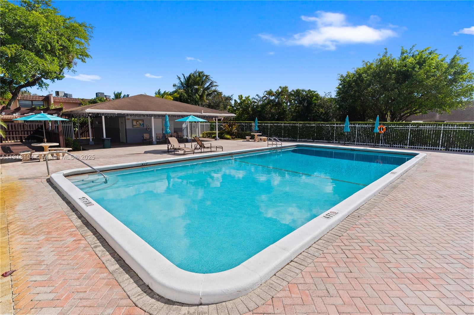 8089 Southwest 18th Court, Unit 27 Davie, FL 33324 - Photo 35 of 36 a view of a swimming pool with lawn chairs under an umbrella