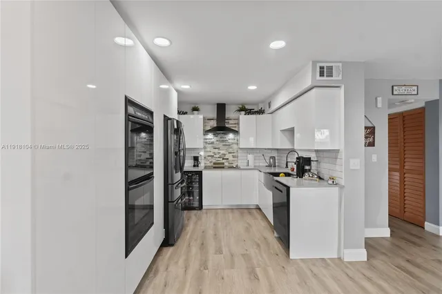 a kitchen with granite countertop a refrigerator and a stove top oven