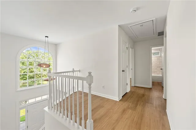 a view of hallway with a window and a chandelier