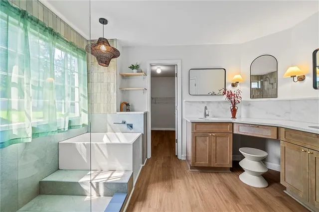 a spacious bathroom with a bathtub shower sink and mirror