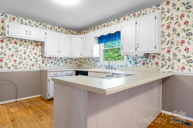 a kitchen with a sink a stove and white cabinets