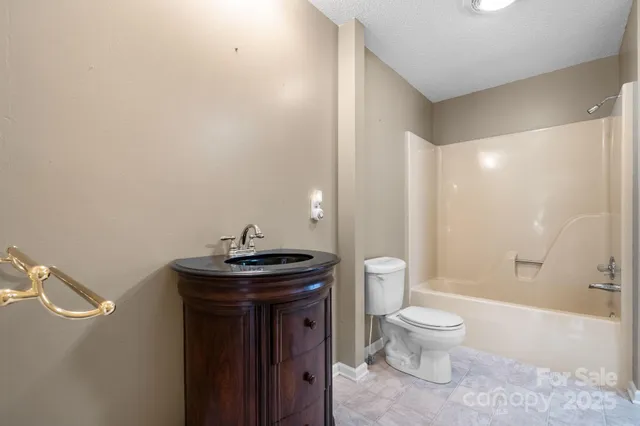 a bathroom with a granite countertop toilet a sink and a bathtub