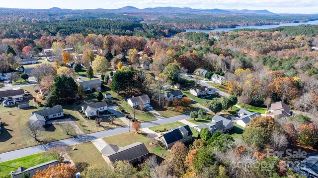 a front view of a house with a garden and trees