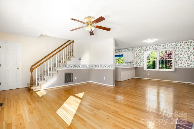 a view of a living room and a kitchen with wooden floor