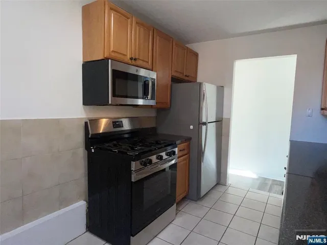 a kitchen with stainless steel appliances granite countertop a refrigerator stove and microwave