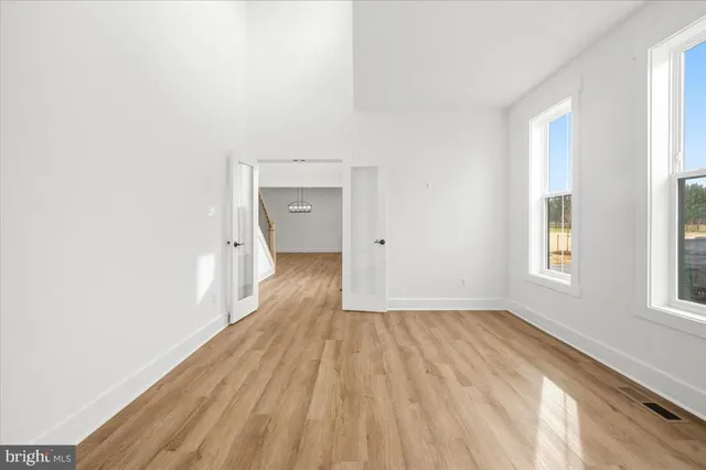 a view of a livingroom with wooden floor and a ceiling fan