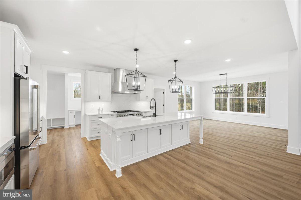 39762 Rivers Edge Lane Lovettsville, VA 20180 - Photo 29 of 118 a large kitchen with stainless steel appliances a stove a sink dishwasher and a refrigerator with wooden floor