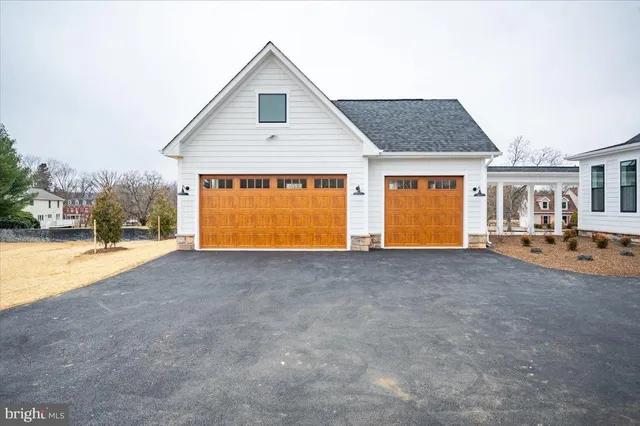 a front view of a house with a yard covered in snow