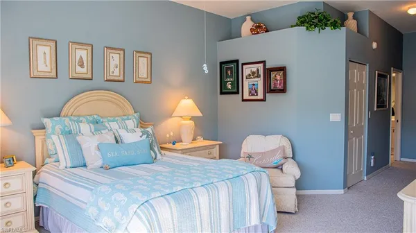 a bed room with a bed and a painting on the wall