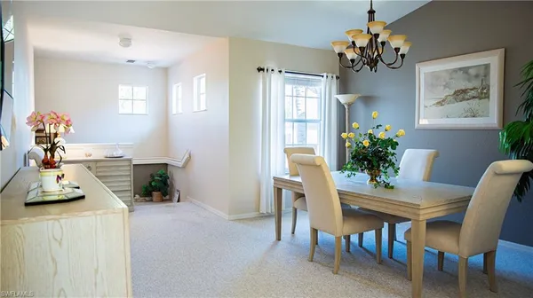 a view of a dining room with furniture and a chandelier