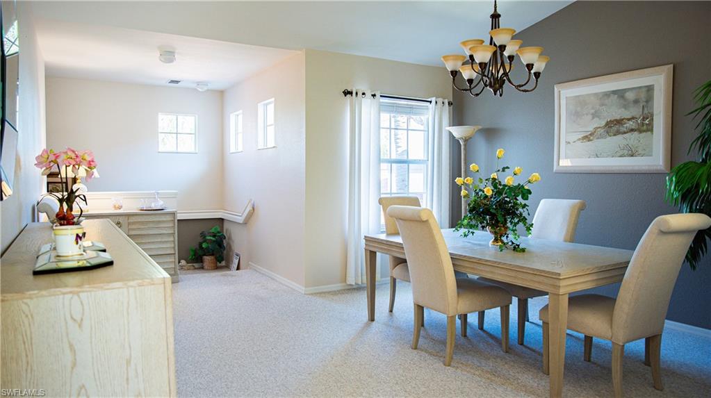 10711 Crooked River Road, Unit 202 Estero, FL 34135 - Photo 3 of 28 a view of a dining room with furniture and a chandelier