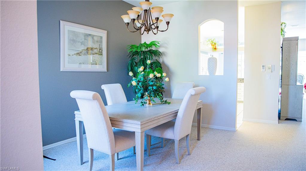 10711 Crooked River Road, Unit 202 Estero, FL 34135 - Photo 4 of 28 a view of a dining room with furniture and a potted plant