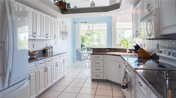 a kitchen with cabinets appliances a sink and a window