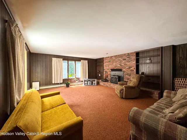 a living room with furniture a large window and a fireplace