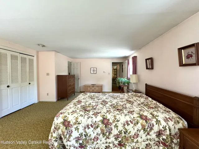 a spacious bedroom with a large bed and wooden floor