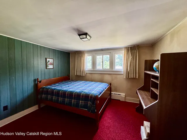 a bedroom with a bed closet and windows