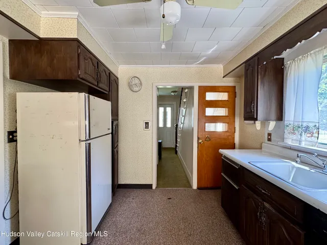 a kitchen with a sink a refrigerator and cabinets