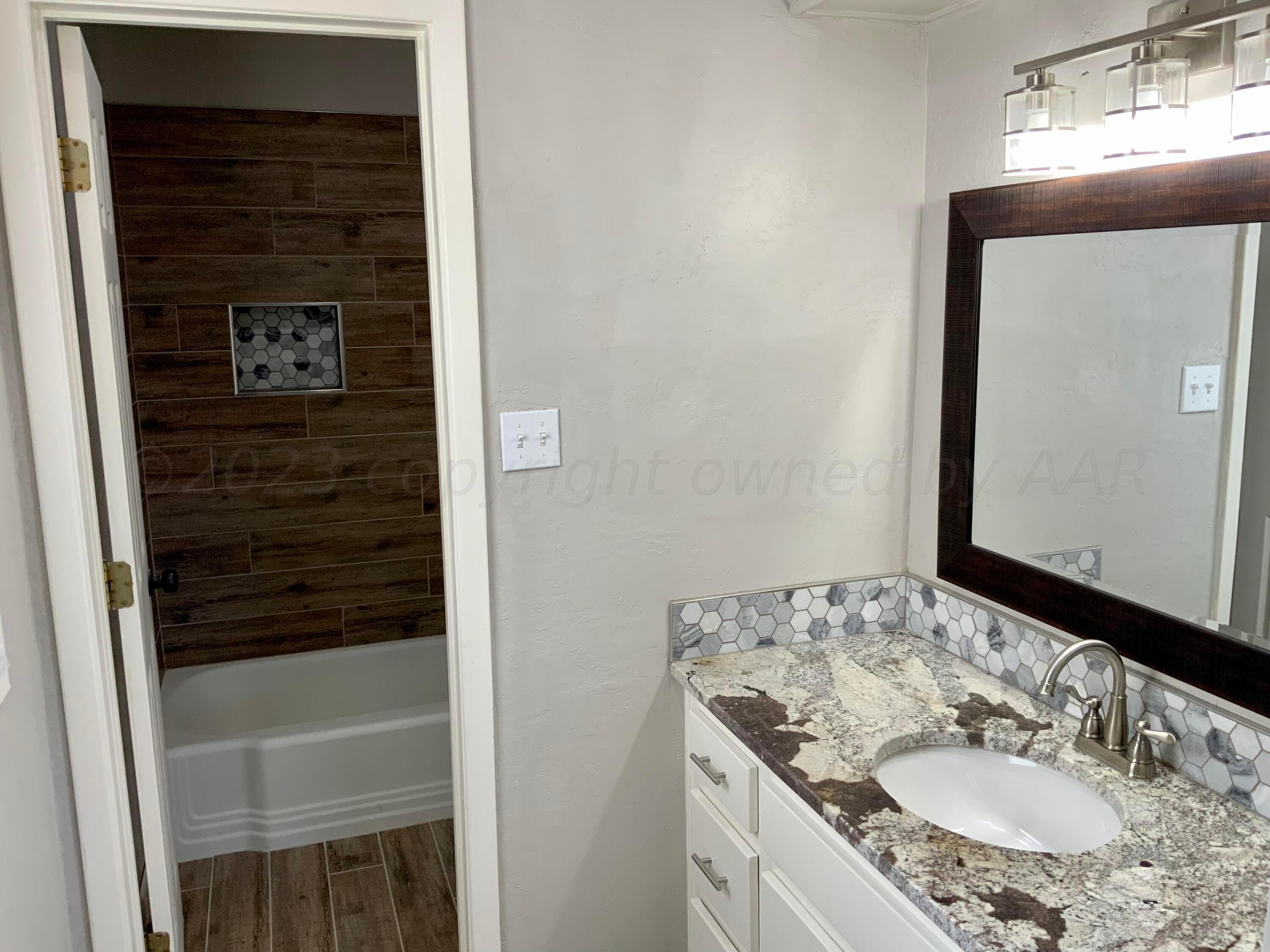 4616 South Rusk Street Amarillo, TX 79110 - Photo 11 of 25 a bathroom with a sink and a mirror