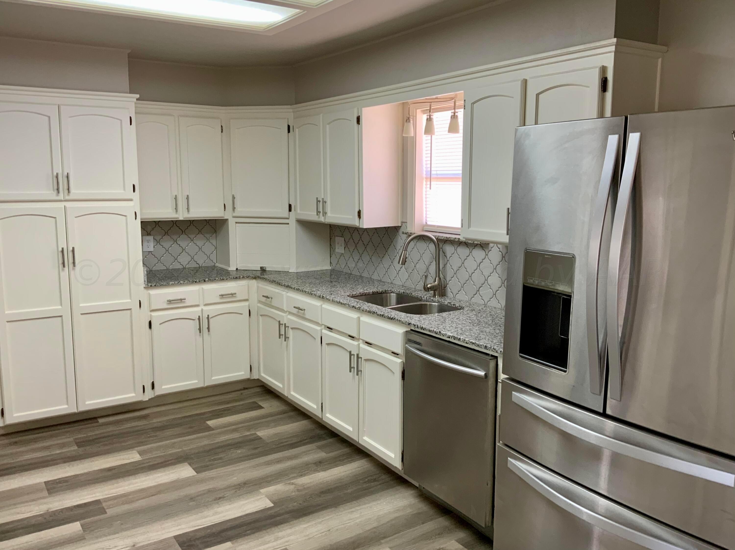 4616 South Rusk Street Amarillo, TX 79110 - Photo 8 of 25 a kitchen with a refrigerator sink and cabinets
