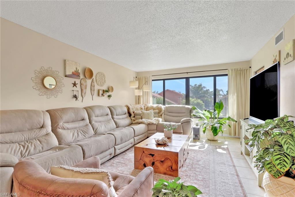 120 Cypress Way East, Unit B5 Naples, FL 34110 - Photo 10 of 24 Living area with a textured ceiling and tile patterned floors