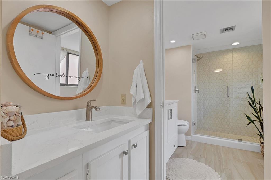 120 Cypress Way East, Unit B5 Naples, FL 34110 - Photo 13 of 24 Full bathroom with vanity, a shower stall, and recessed lighting