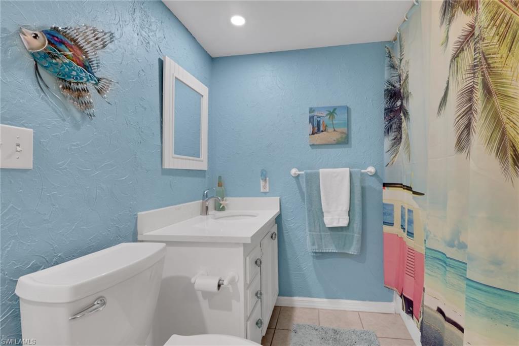 120 Cypress Way East, Unit B5 Naples, FL 34110 - Photo 16 of 24 Full bathroom featuring a textured wall, vanity, light tile patterned flooring, recessed lighting, and curtained shower