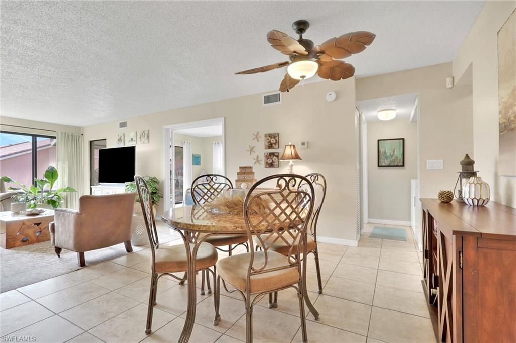 120 Cypress Way East, Unit B5 Naples, FL 34110 - Photo 7 of 24 Dining room with a textured ceiling, light tile patterned flooring, and ceiling fan