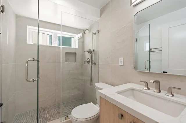 a bathroom with a sink toilet vanity and shower