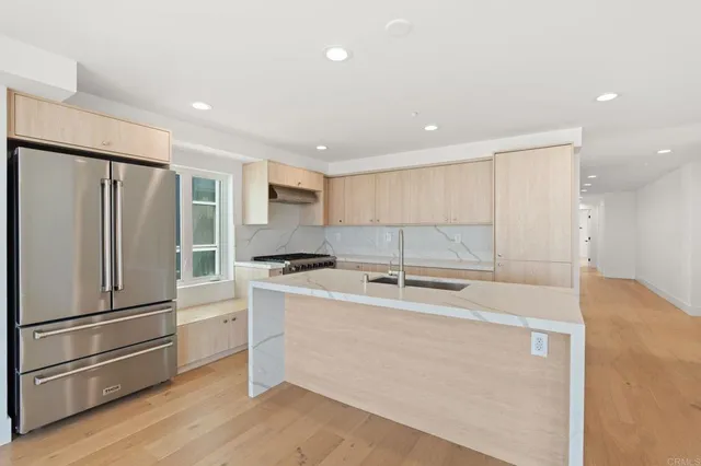 a kitchen with stainless steel appliances granite countertop a refrigerator a sink and a stove