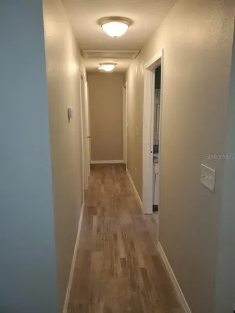 a view of a hallway with wooden floor