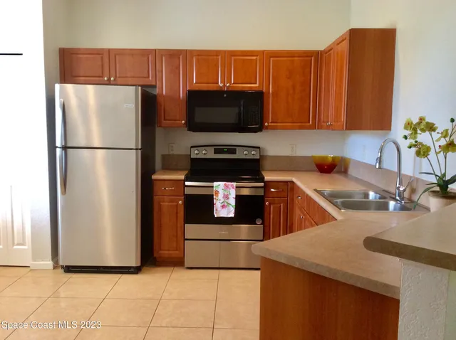 a kitchen with stainless steel appliances a refrigerator a stove a sink a microwave and island