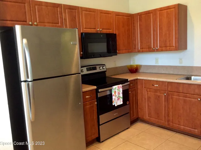a kitchen with stainless steel appliances granite countertop a refrigerator stove and cabinets