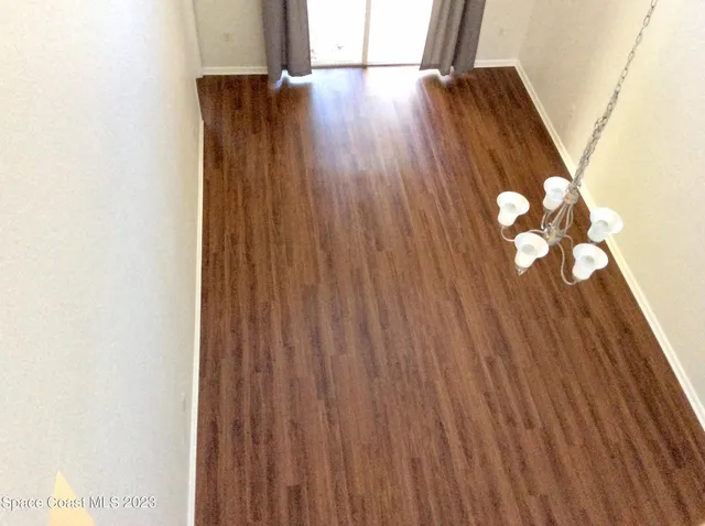 a view of an empty room with wooden floor