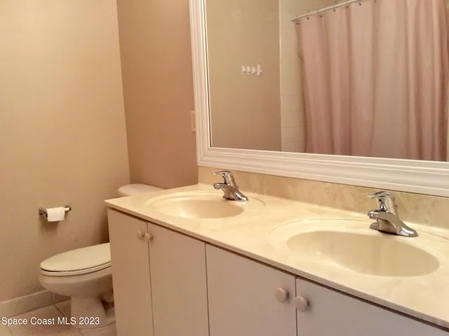 a bathroom with a sink a toilet and mirror