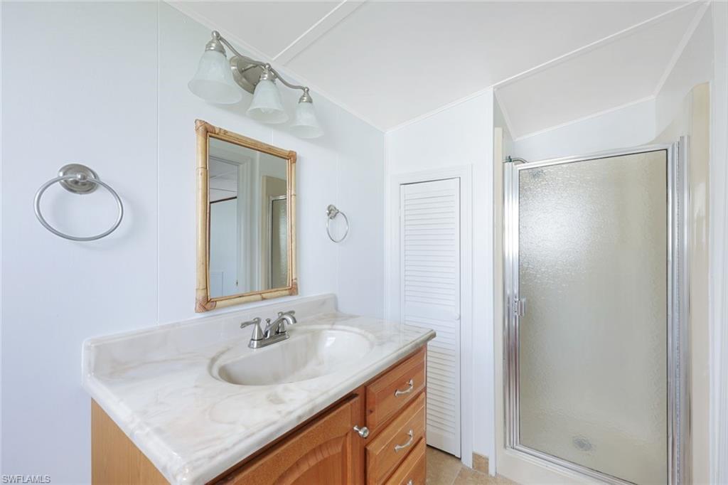 171 Grassy Key Lane, Unit 48 Naples, FL 34114 - Photo 12 of 19 a bathroom with a sink vanity and a mirror