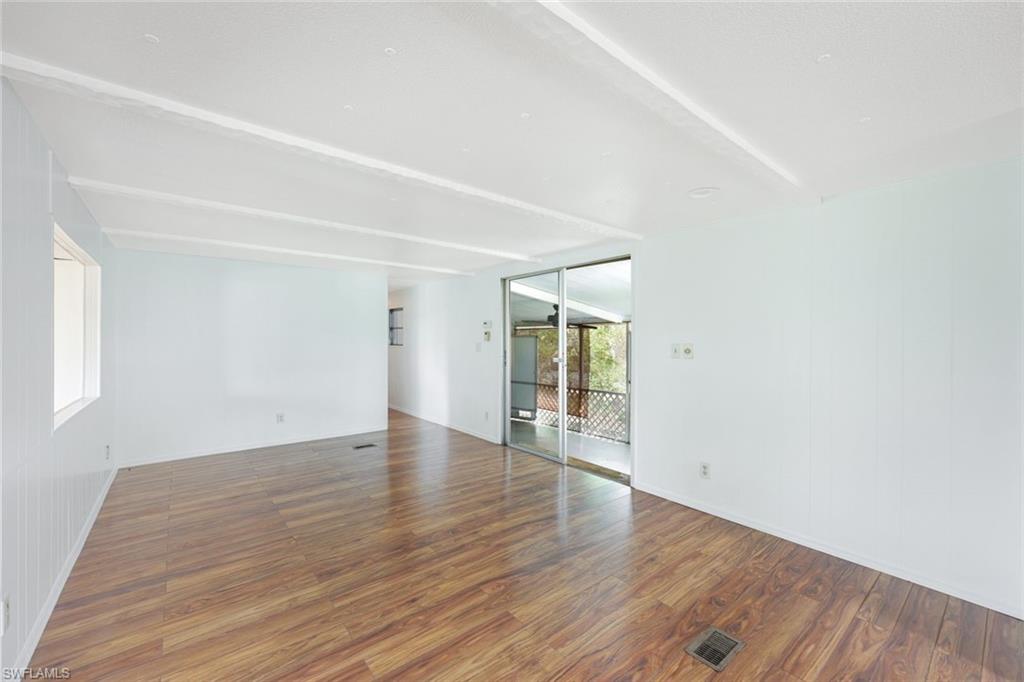 171 Grassy Key Lane, Unit 48 Naples, FL 34114 - Photo 4 of 19 a view of an empty room with wooden floor and a window