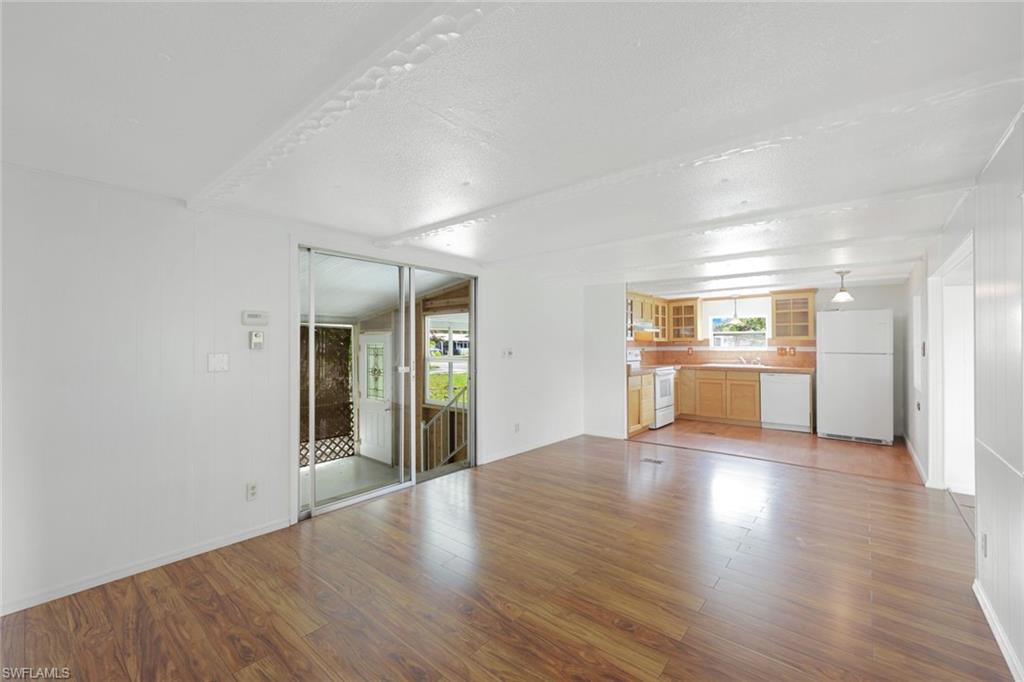 171 Grassy Key Lane, Unit 48 Naples, FL 34114 - Photo 5 of 19 a view of a big room with wooden floor and a kitchen