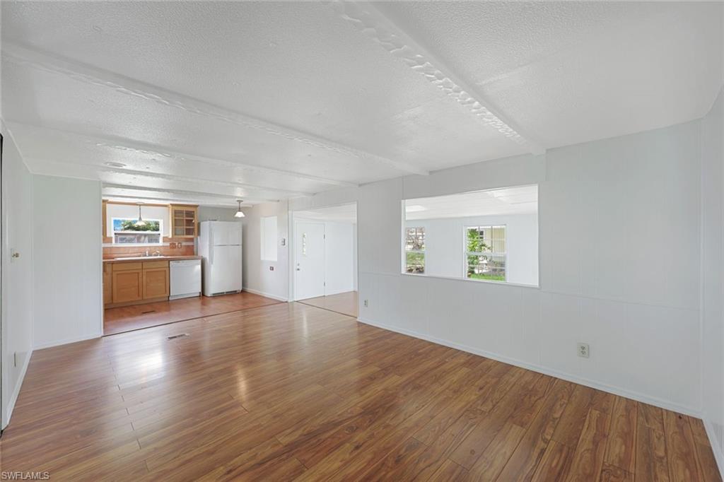 171 Grassy Key Lane, Unit 48 Naples, FL 34114 - Photo 6 of 19 an empty room with wooden floor and windows