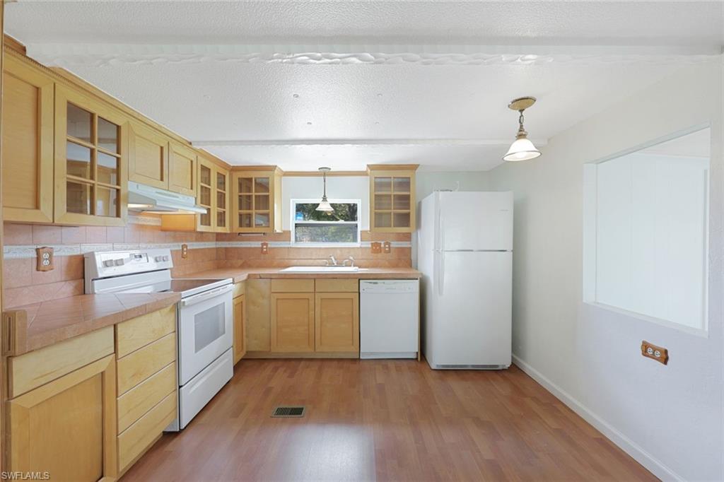 171 Grassy Key Lane, Unit 48 Naples, FL 34114 - Photo 7 of 19 a kitchen with a refrigerator and a stove top oven