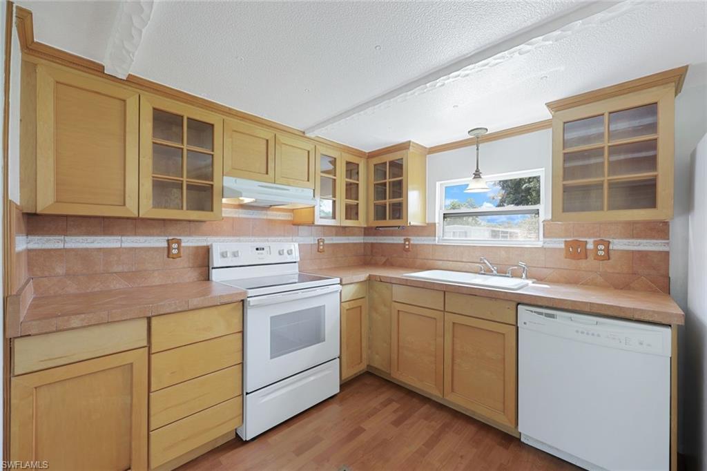 171 Grassy Key Lane, Unit 48 Naples, FL 34114 - Photo 8 of 19 a kitchen with a sink stove and cabinets